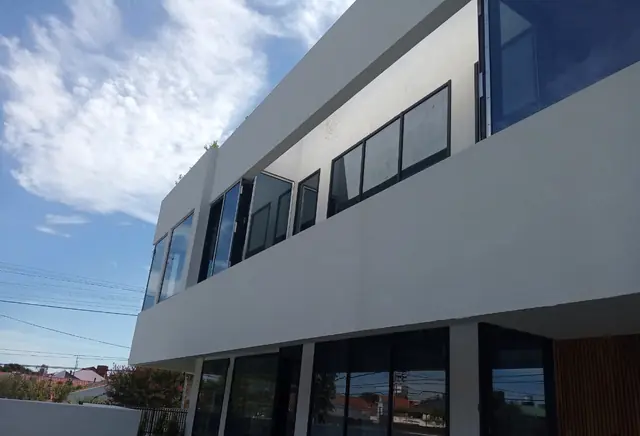 Fachada blanca con ventanales en dos niveles, trabajo de GO!
