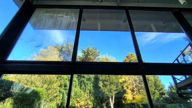 Ventanal de piso a techo con vista a un jardín